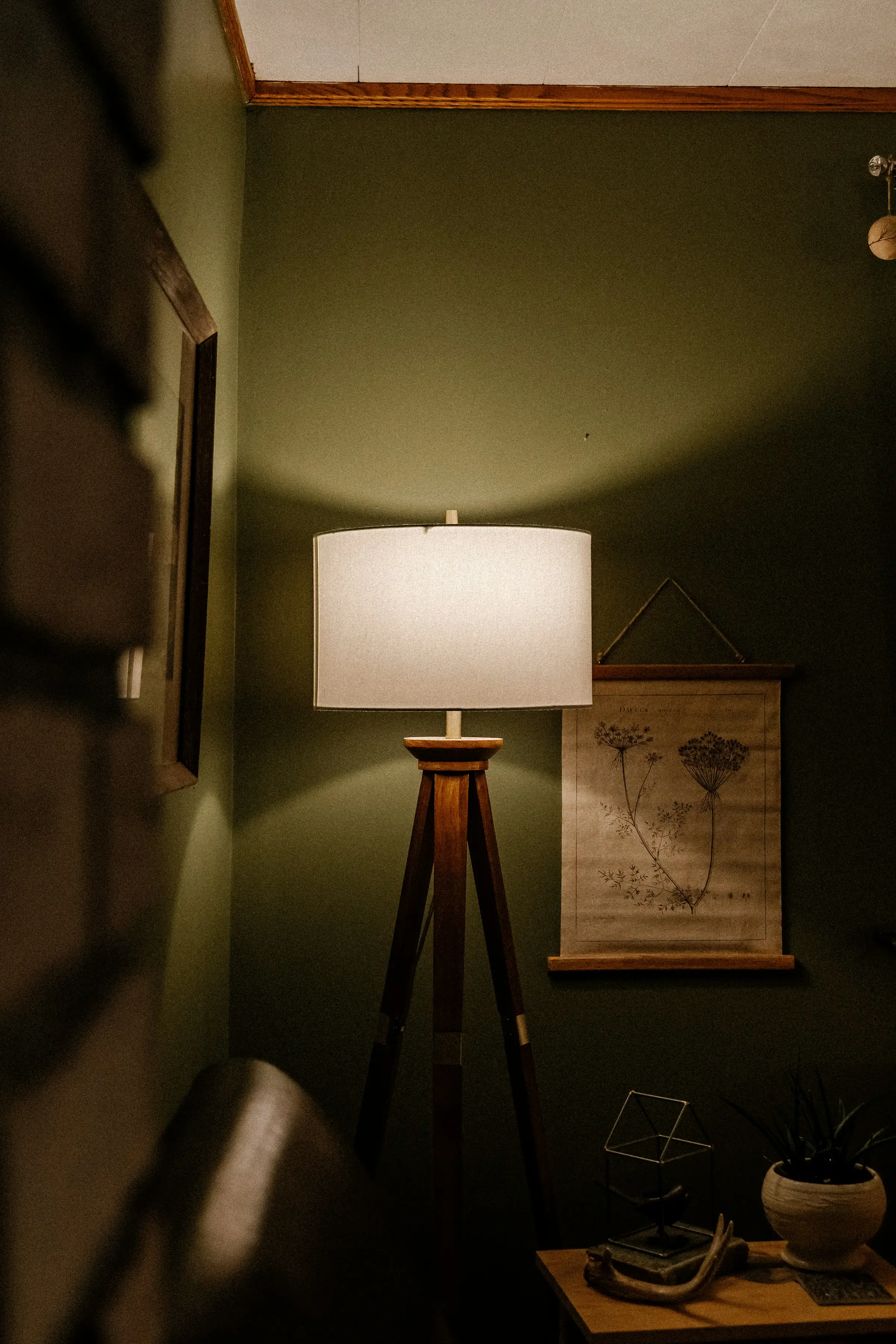 Lámpara de pie encendida junto a una mesa de madera en un ambiente cálido