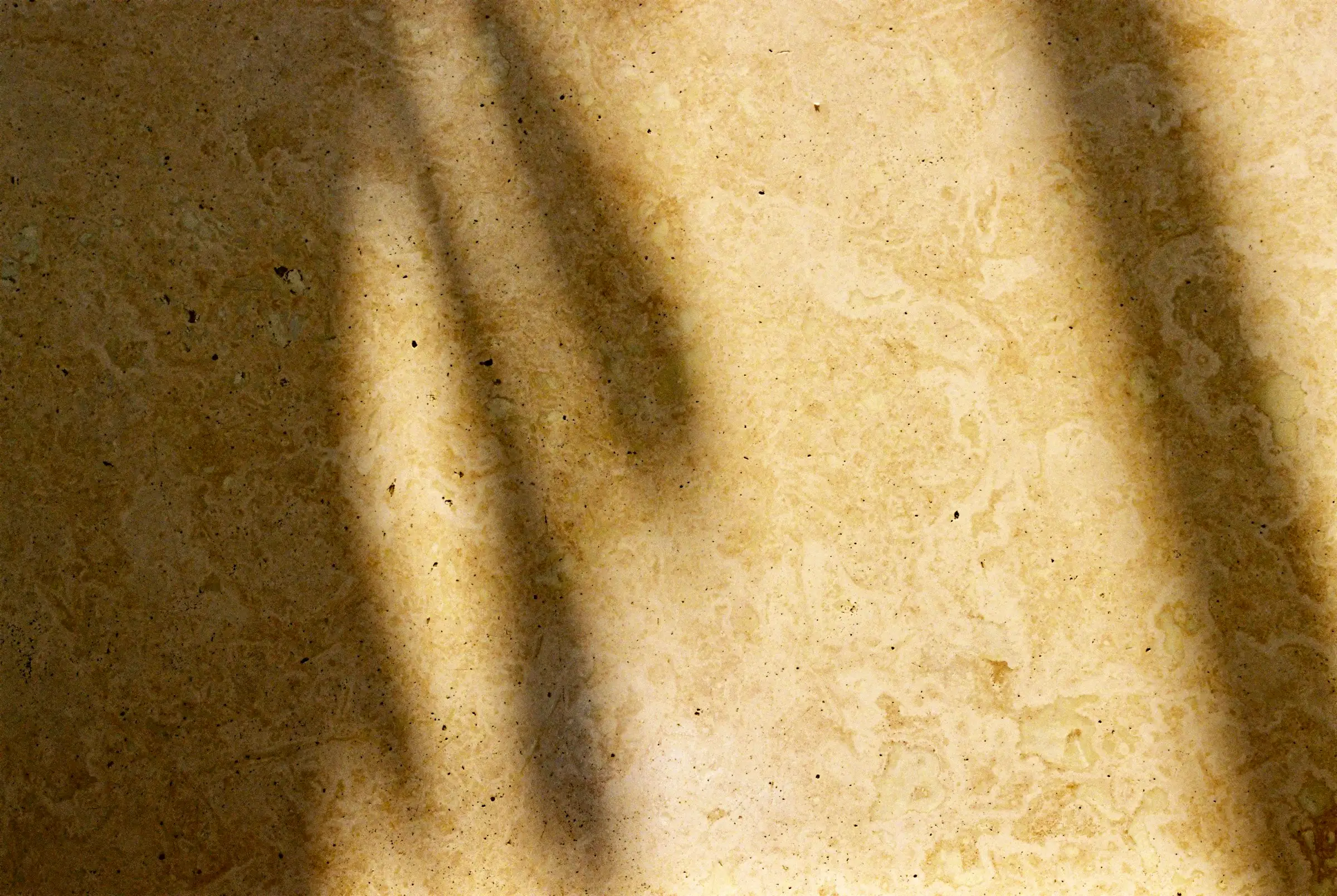 Suelo de piedra crema con sombras de ventana